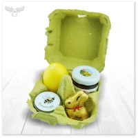 Osterpräsent im Eierkarton mit Schokolade-Hase, Marmelade, Blumensamen und Osterei-Kerze